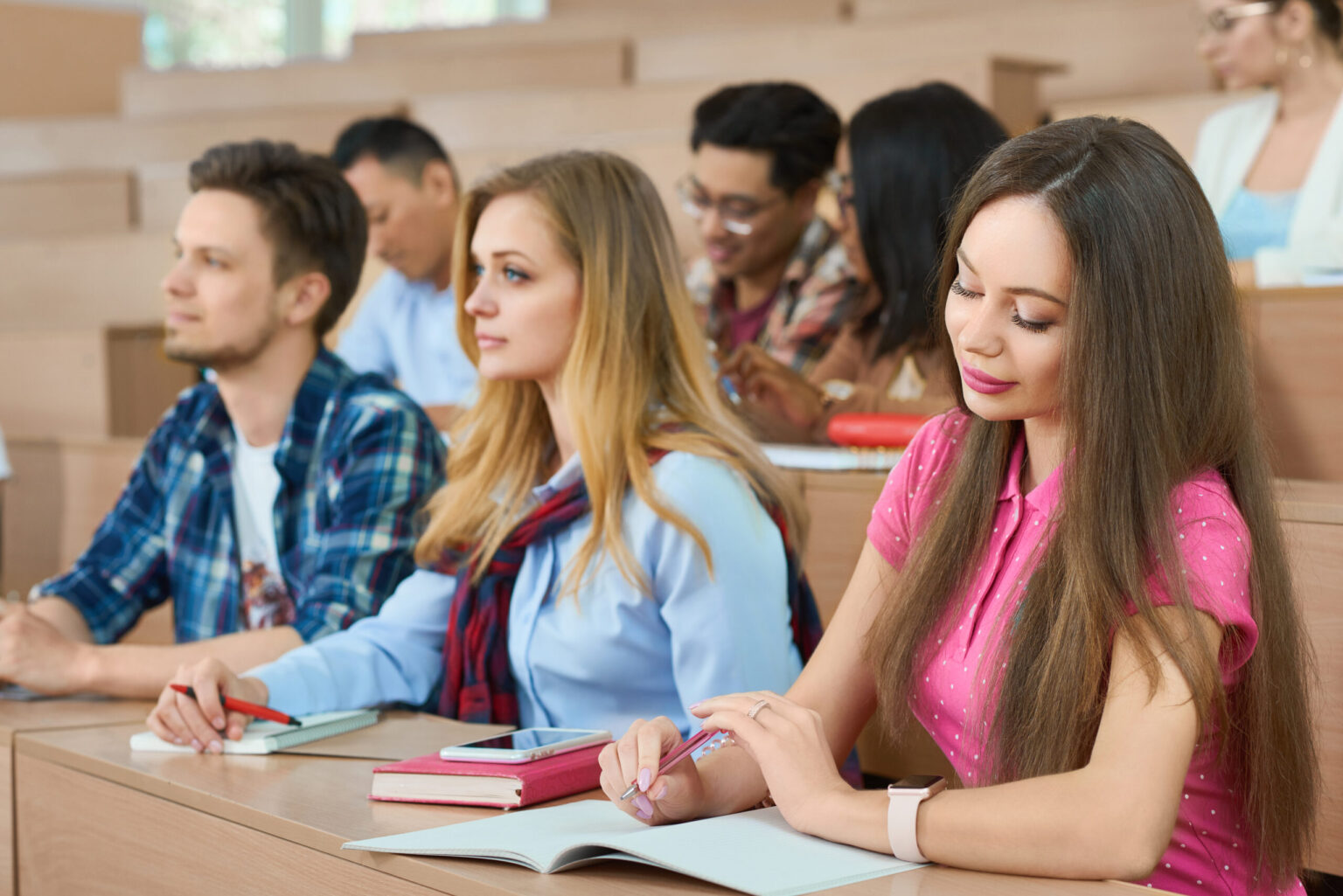 Students taking notes in a lecture hall